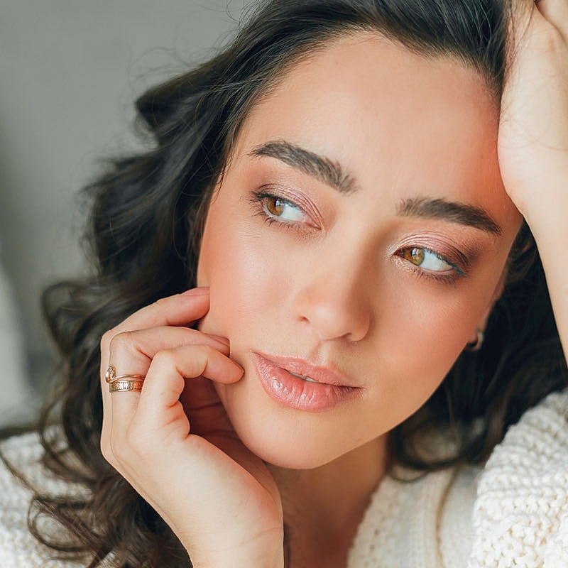 Close-up of a thoughtful woman with curly hair.