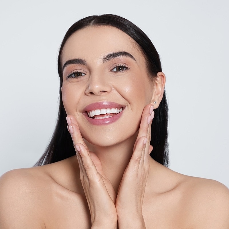 Smiling woman showcasing healthy, glowing skin.