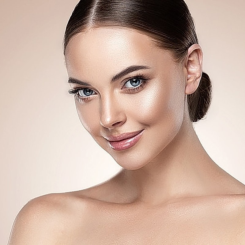 Smiling woman with glowing skin and blue eyes