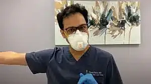 Medical professional wearing mask and gloves.
