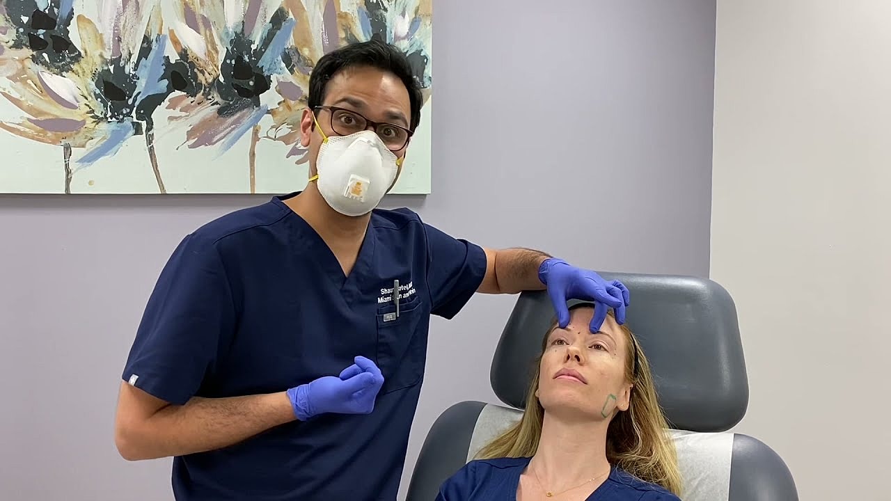 Doctor performing cosmetic treatment on patient.