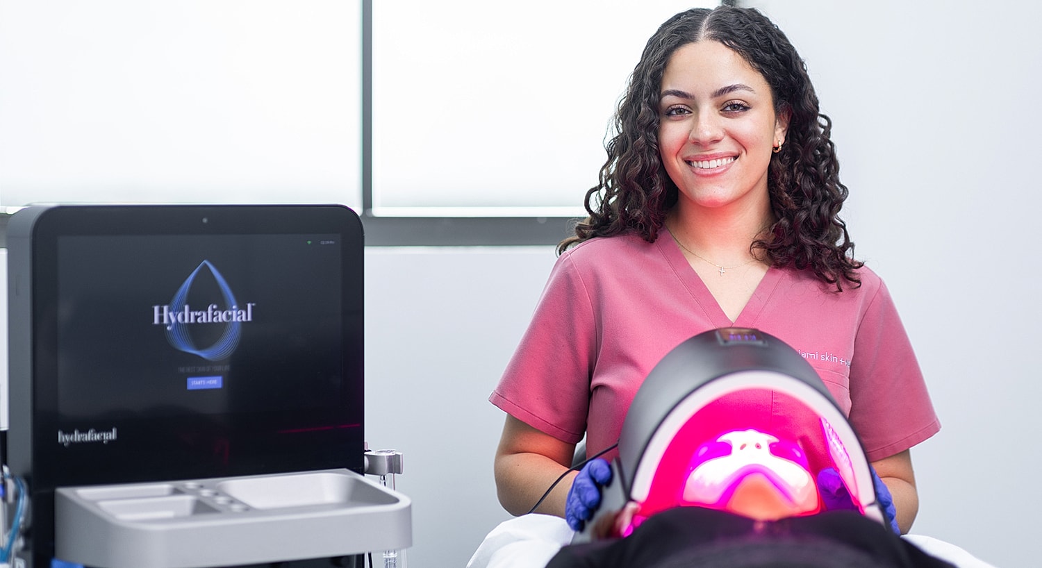 HydraFacial treatment session with smiling technician.