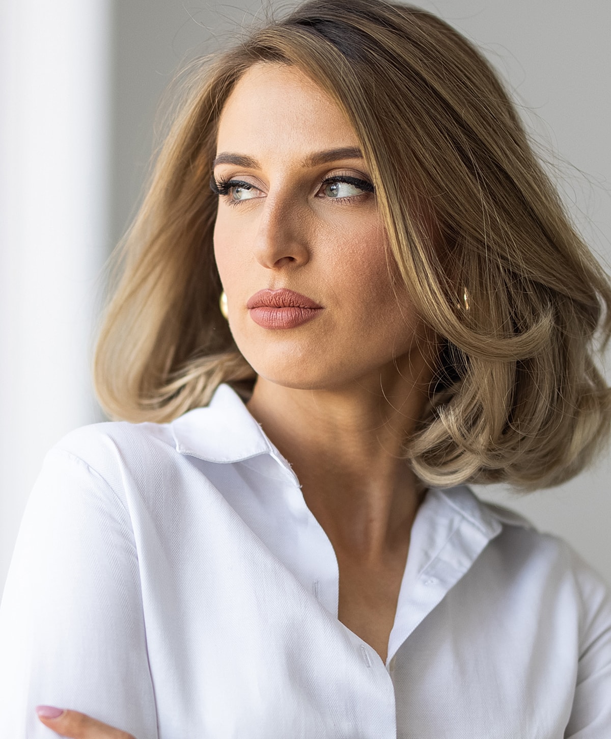 Woman with elegant hairstyle and white blouse.