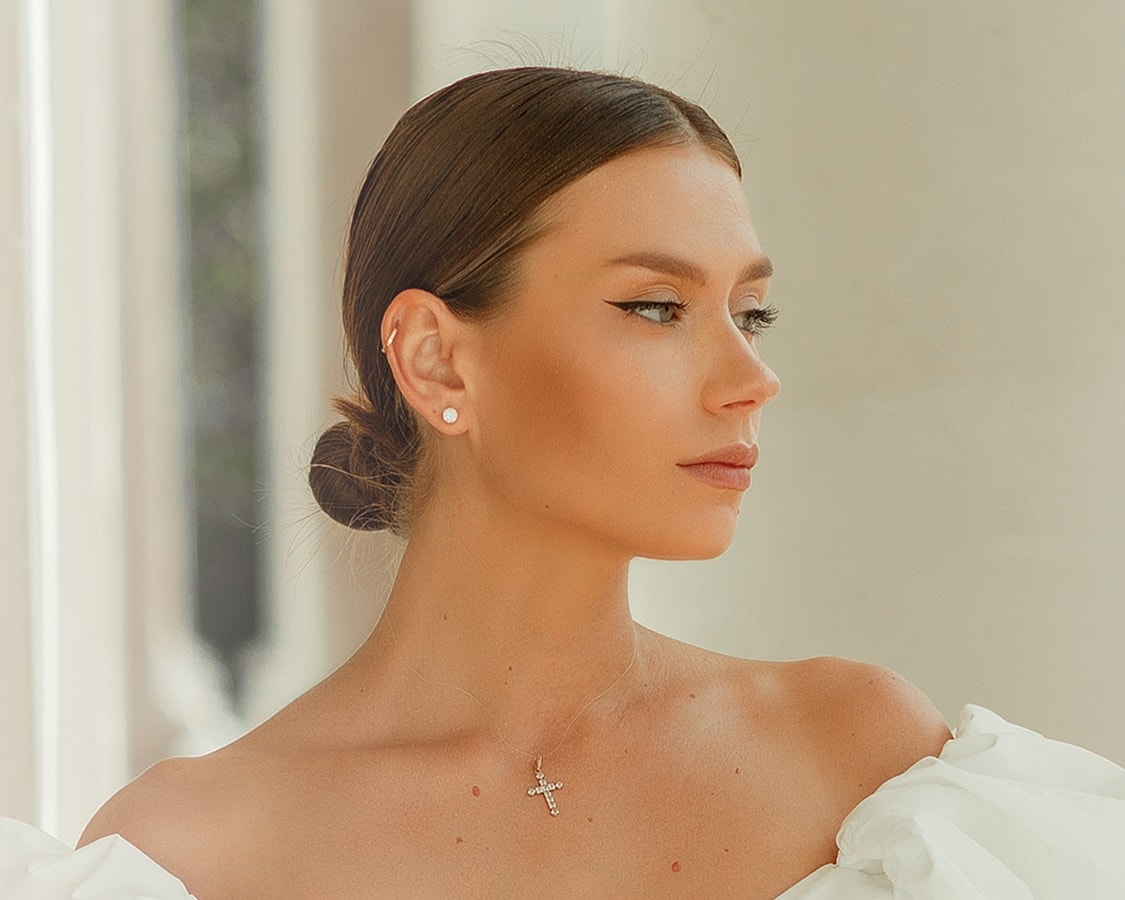 Profile of a woman with elegant hairstyle and jewelry.
