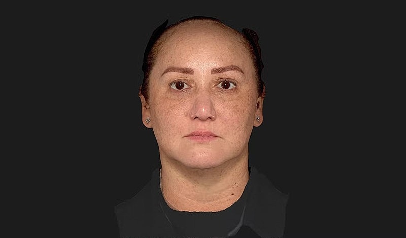 Woman with light skin and freckles, neutral expression.