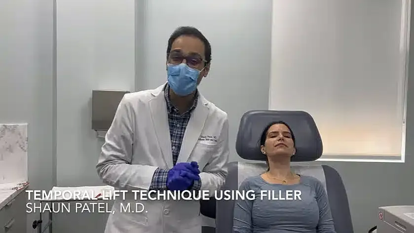 Doctor demonstrating temporal lift with filler.
