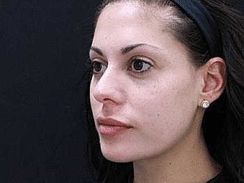 Young woman with subtle makeup and black background.