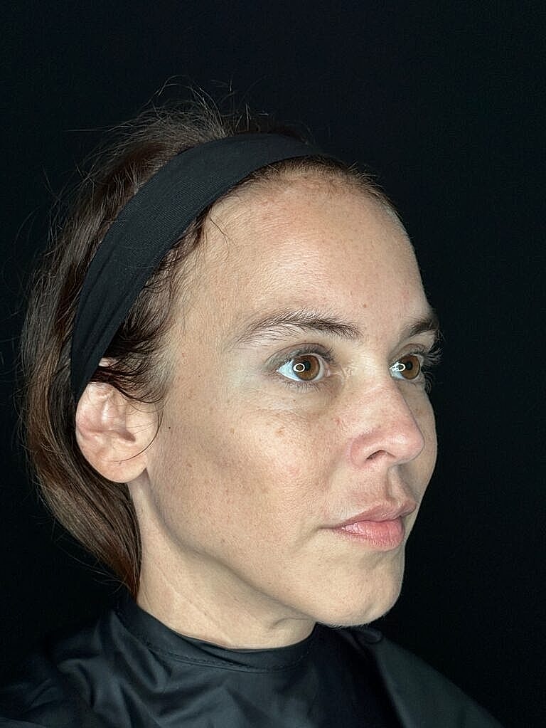 Woman with a headband, black background portrait.