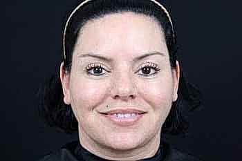 Person smiling against a black background.