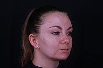 Woman with serious expression against dark background