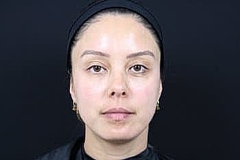 Person with natural makeup against dark background