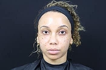 Person with natural makeup and curly hair.