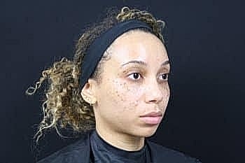 Woman with curly hair and natural makeup.