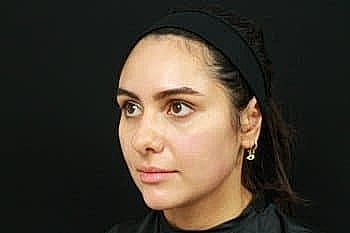 Woman with a headband against a black background.