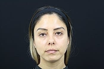 Portrait of a woman against dark background.