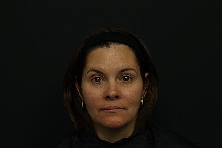 Woman with medium-length hair against dark background.