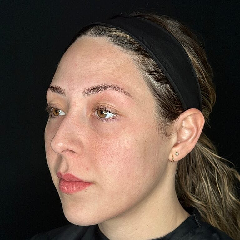 Woman with natural makeup against black background.