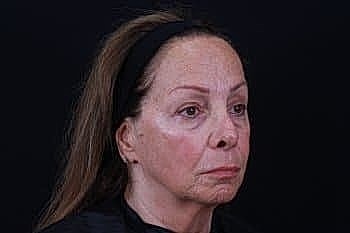 Serious woman with long hair against black background