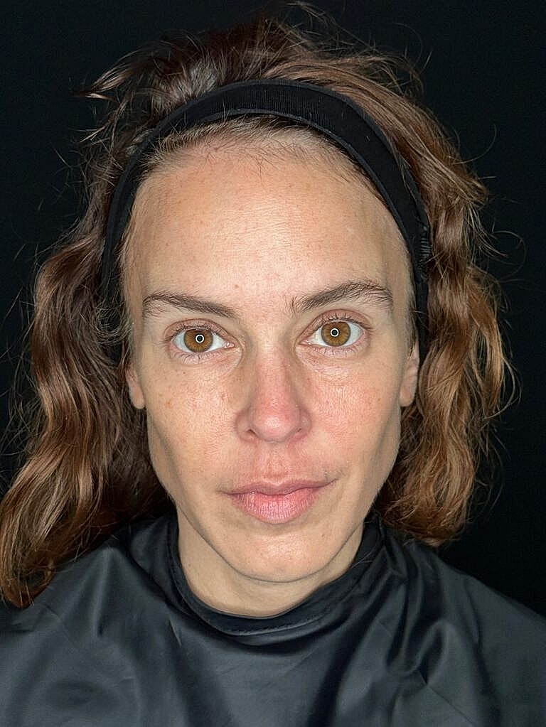 Woman with natural makeup and wavy hair.