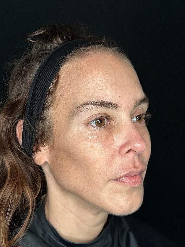 Profile portrait of a woman with ponytail.