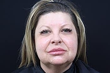 Woman with light hair and neutral expression.