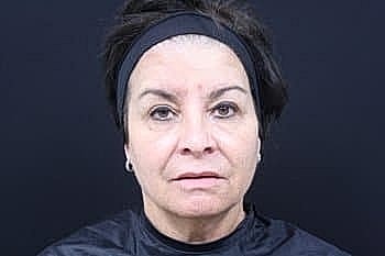 Woman with dark hair and neutral expression.