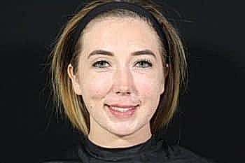 Woman with short hair against a black background.