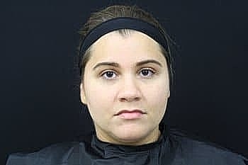 Person with neutral expression against black background.