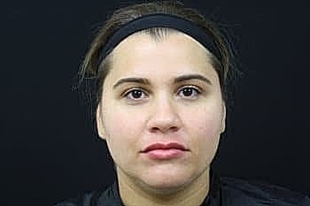 Woman with neutral expression against dark background