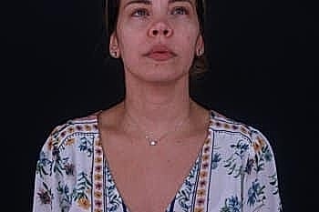 Woman in floral dress against dark background.