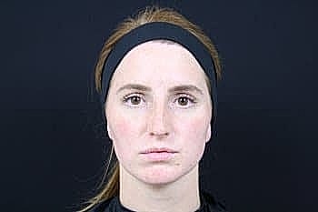 Serious athlete with headband against dark background