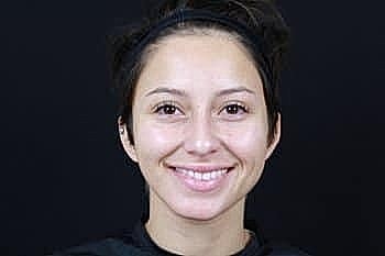 Smiling woman with short hair against black background