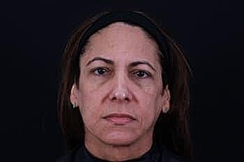 Woman with long hair against dark background.