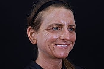 Smiling woman with long hair and headband.