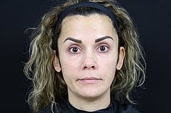 Person with curly hair and natural makeup.