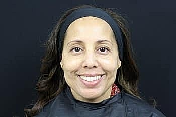 Woman smiling with long hair and headband.