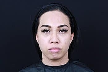 Person with makeup and black backdrop.
