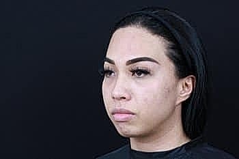Woman with straight hair against black background
