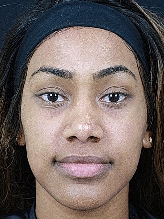 Young woman with natural makeup and dark hair.