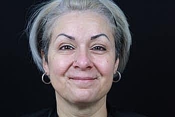 Smiling woman with short grey hair.