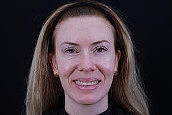 Smiling woman with long hair against dark background