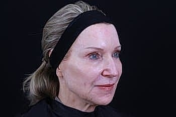 Older woman with natural beauty, dark background.