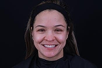 Smiling woman with dark background, natural look.