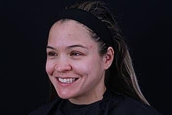 Smiling woman with natural makeup and headband.
