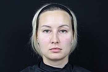 Portrait of a woman with neutral expression.