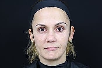 Woman with natural makeup against black background.