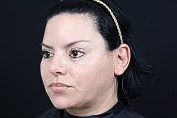 Woman with dark hair and light makeup.