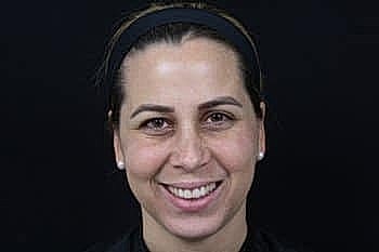 Smiling person with dark background.