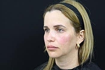 Woman with blonde hair and hoop earrings.