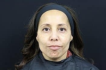 Woman with long hair, wearing a black cape.